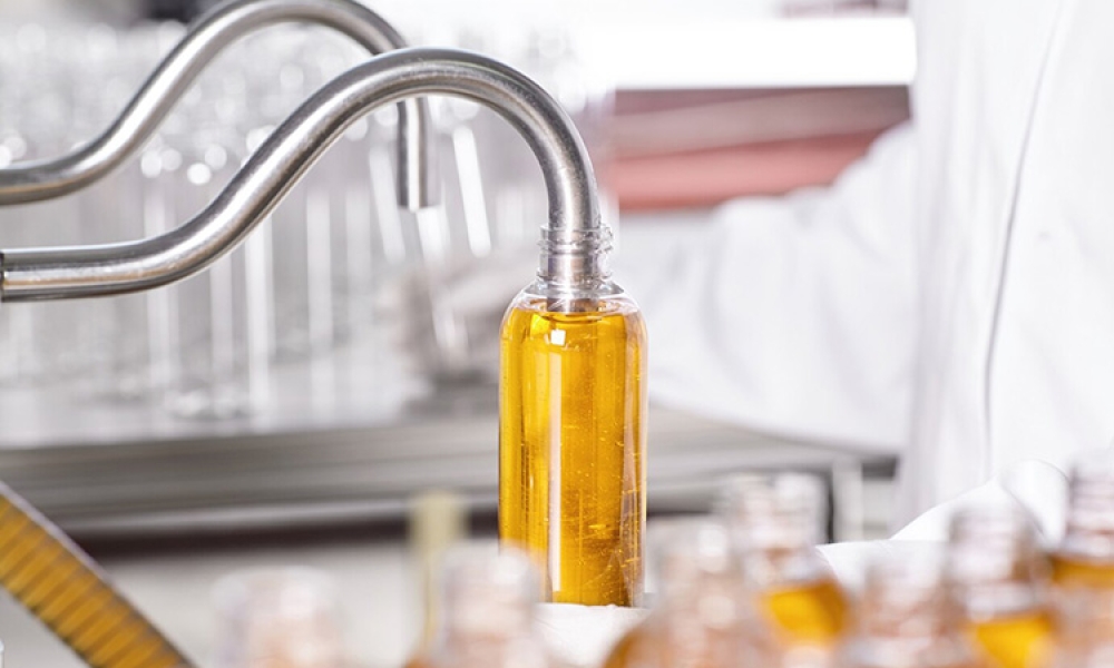 factory-worker-white-gown-rubber-gloves-holding-plastic-bottle